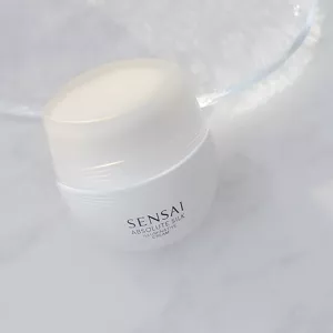 SENSAI's Absolute Silk Illuminative Cream jar shown on white marble surface